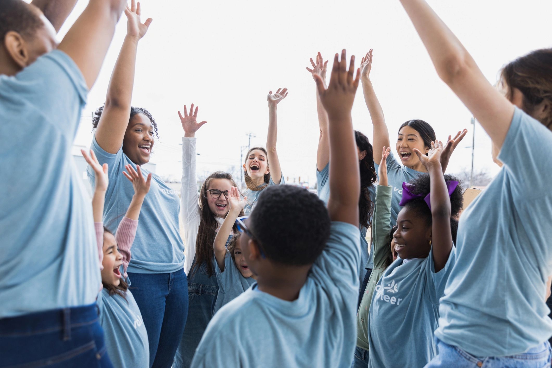 Volunteer team cheering with hands raised