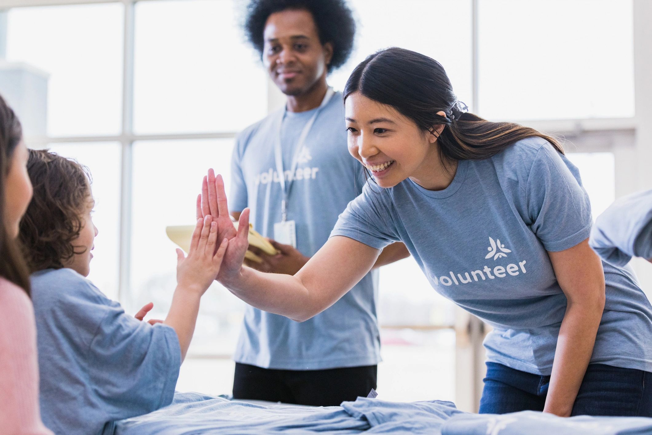 Volunteer high-fiving a child at a community event