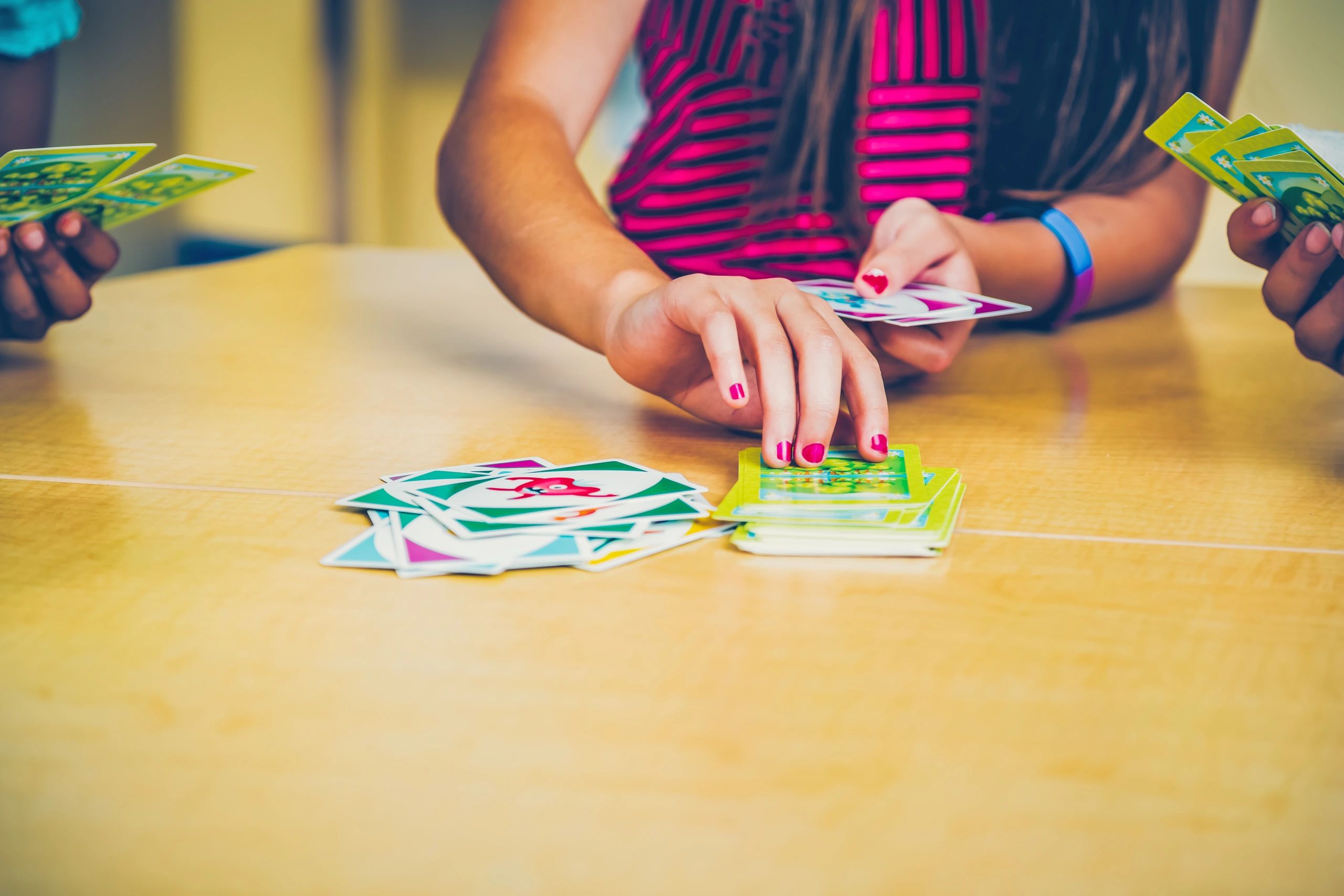 Kids playing a card game together at a table