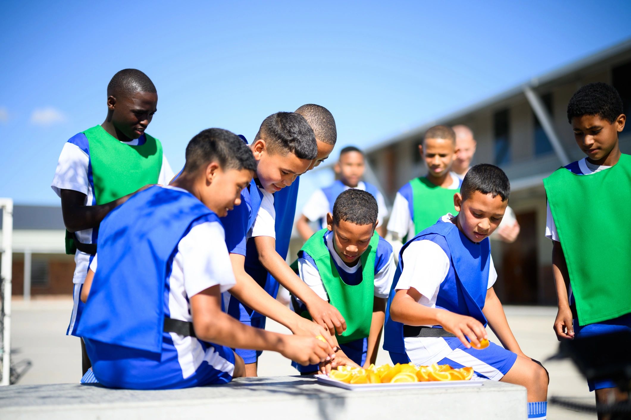 Kids eating oranges at halftime during a school soccer match