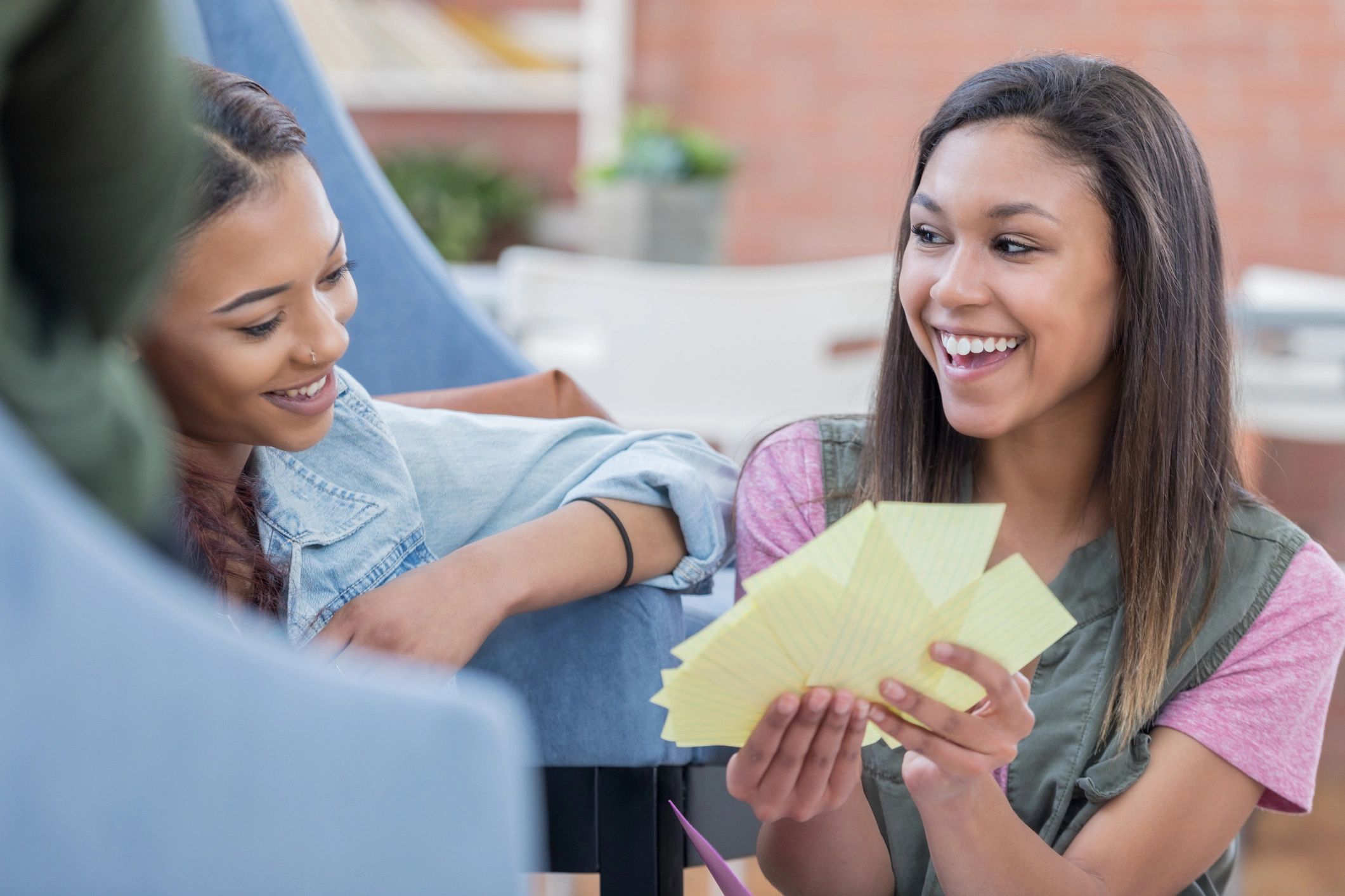 Teens studying together using note cards at a table
